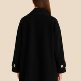 Elegant dameponcho i uldlook med knapdetaljer og løs pasform