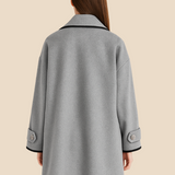 Elegant dameponcho i uldlook med knapdetaljer og løs pasform