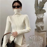 Elegant sort ribstrikket bluse med hvide kanter og asymmetrisk detalje