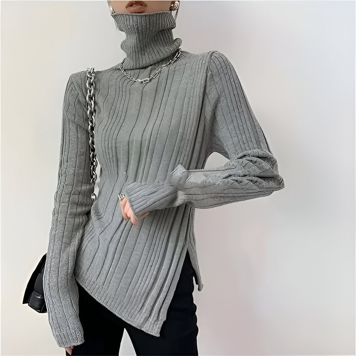 Elegant sort ribstrikket bluse med hvide kanter og asymmetrisk detalje