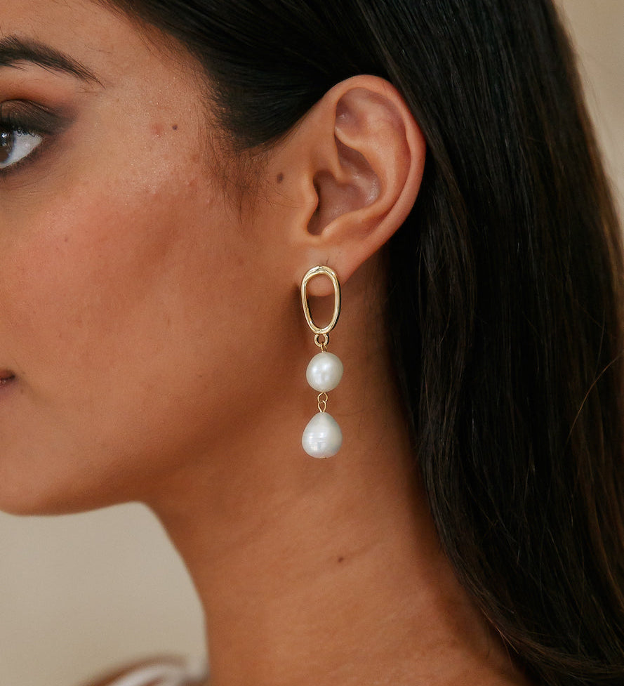 Guld dråbeøreringe med hvide perler – elegant og tidløs stil