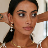 Guld dråbeøreringe med hvide perler – elegant og tidløs stil