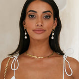 Guld dråbeøreringe med hvide perler – elegant og tidløs stil