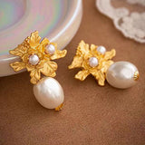 Guld blomsterøreringe med perlevedhæng – luksuriøst og feminint design