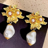 Guld blomsterøreringe med perlevedhæng – luksuriøst og feminint design