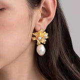 Guld blomsterøreringe med perlevedhæng – luksuriøst og feminint design