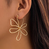 Guld blomsterøreringe i tråddesign – moderne og elegant statement-smykke